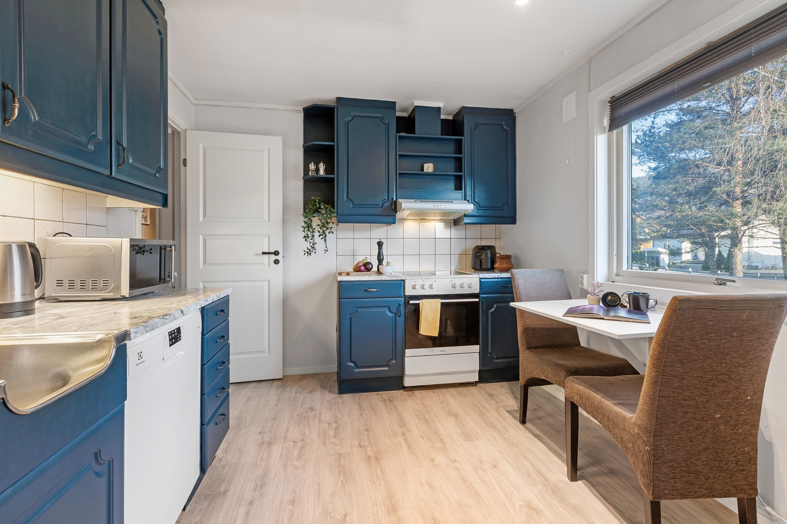 Kjøkken med oppgraderte overflater, god skapplass og rom til spiseplass ved vinduet. Galleribilde