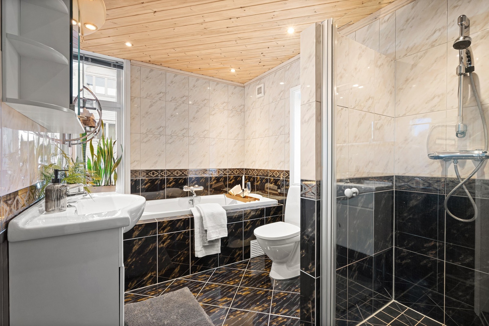 Utstyrt med bad med speil, benkeskap, servant, dusj med glassdør og badekar. Galleribilde