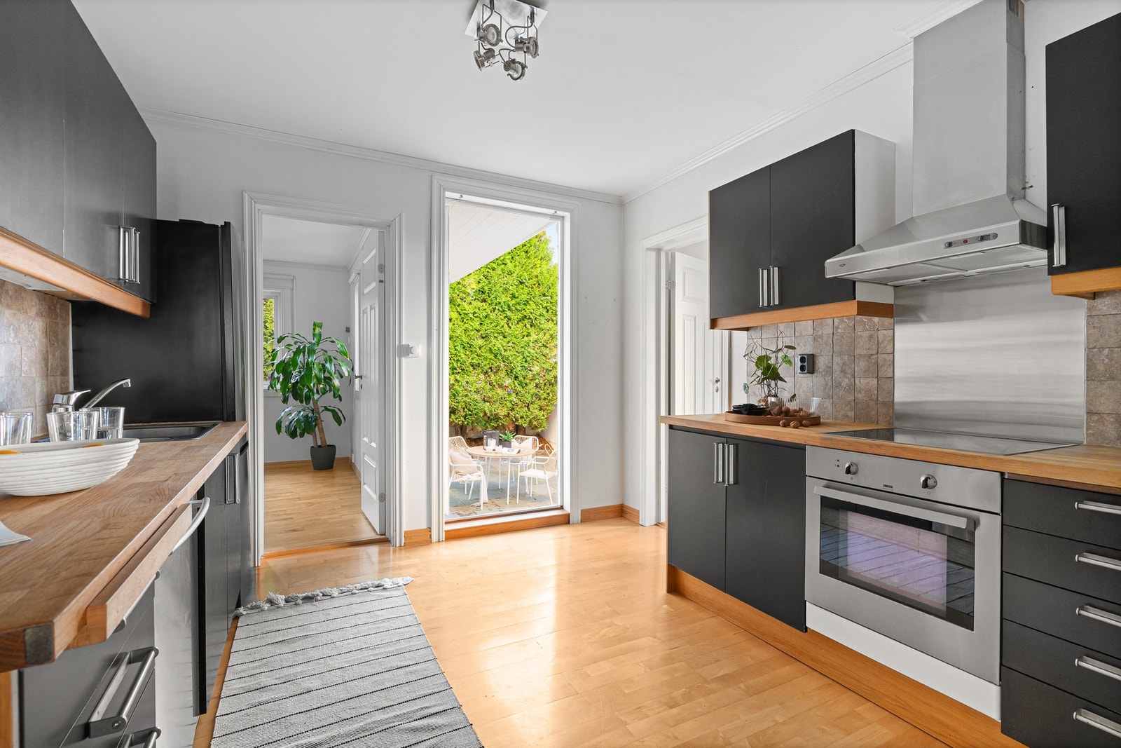 Ikea-kjøkken med integrerte hvitevarer. Frittstående kjøleskap. Videre tilkomst til uteareal. Galleribilde