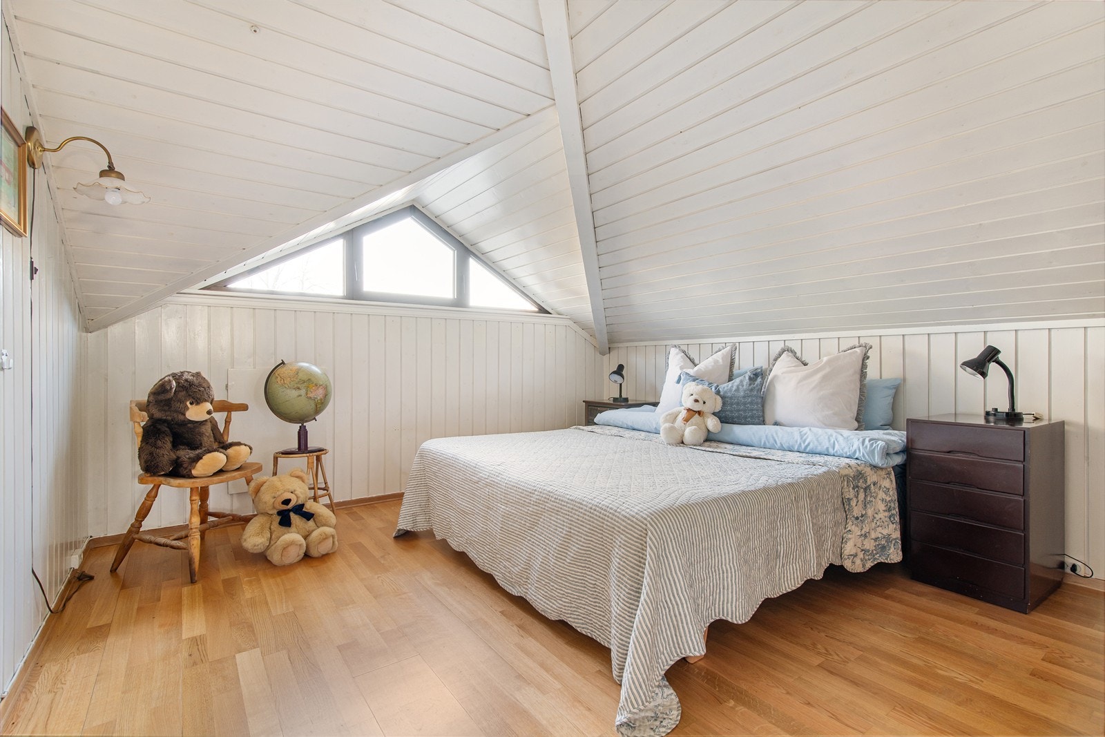 Master bedroom med karakteristiske skråvinduer som følger takets form Galleribilde