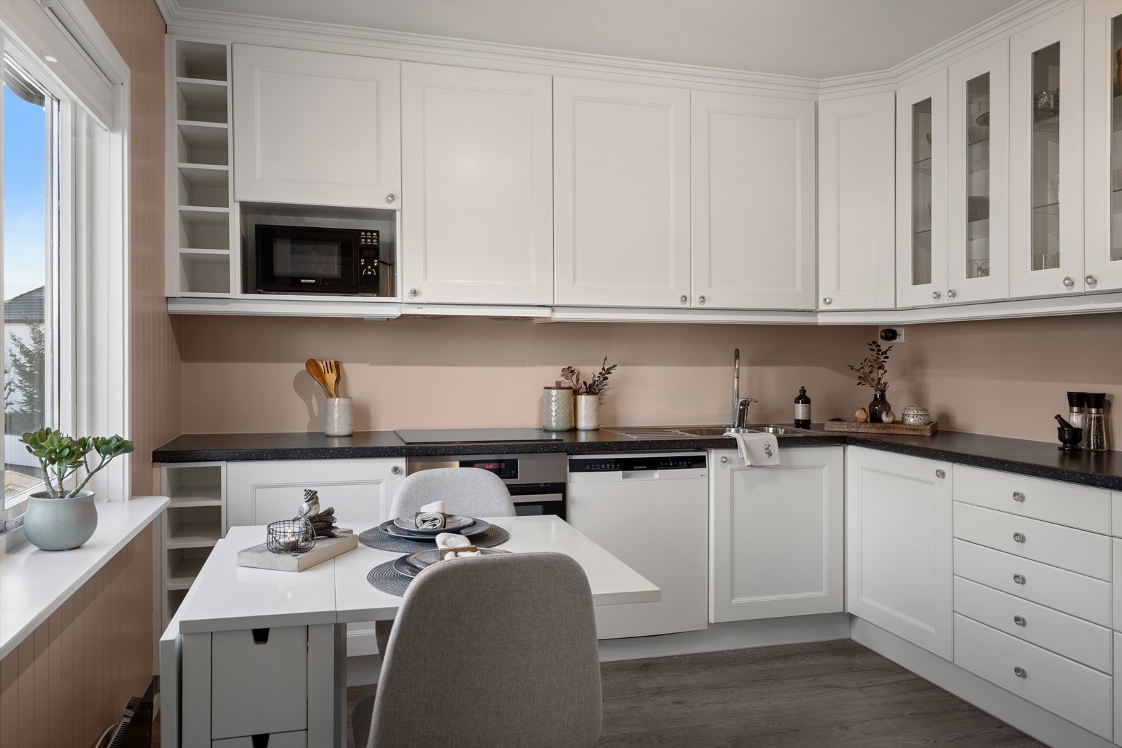 Videre er det belysning under overskap og malte flater på vegg over benkeplate i laminat, og dobbel stålkum med ett-greps blandebatteri. Galleribilde