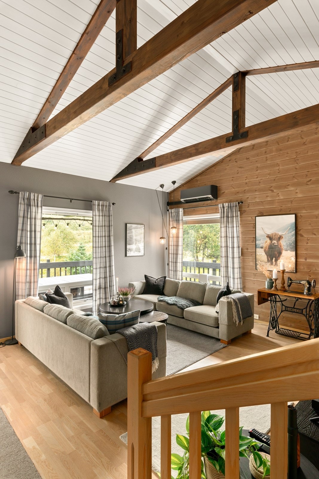 Skråhimling med eksponerte bjelker gir stuen god takhøyde. Galleribilde