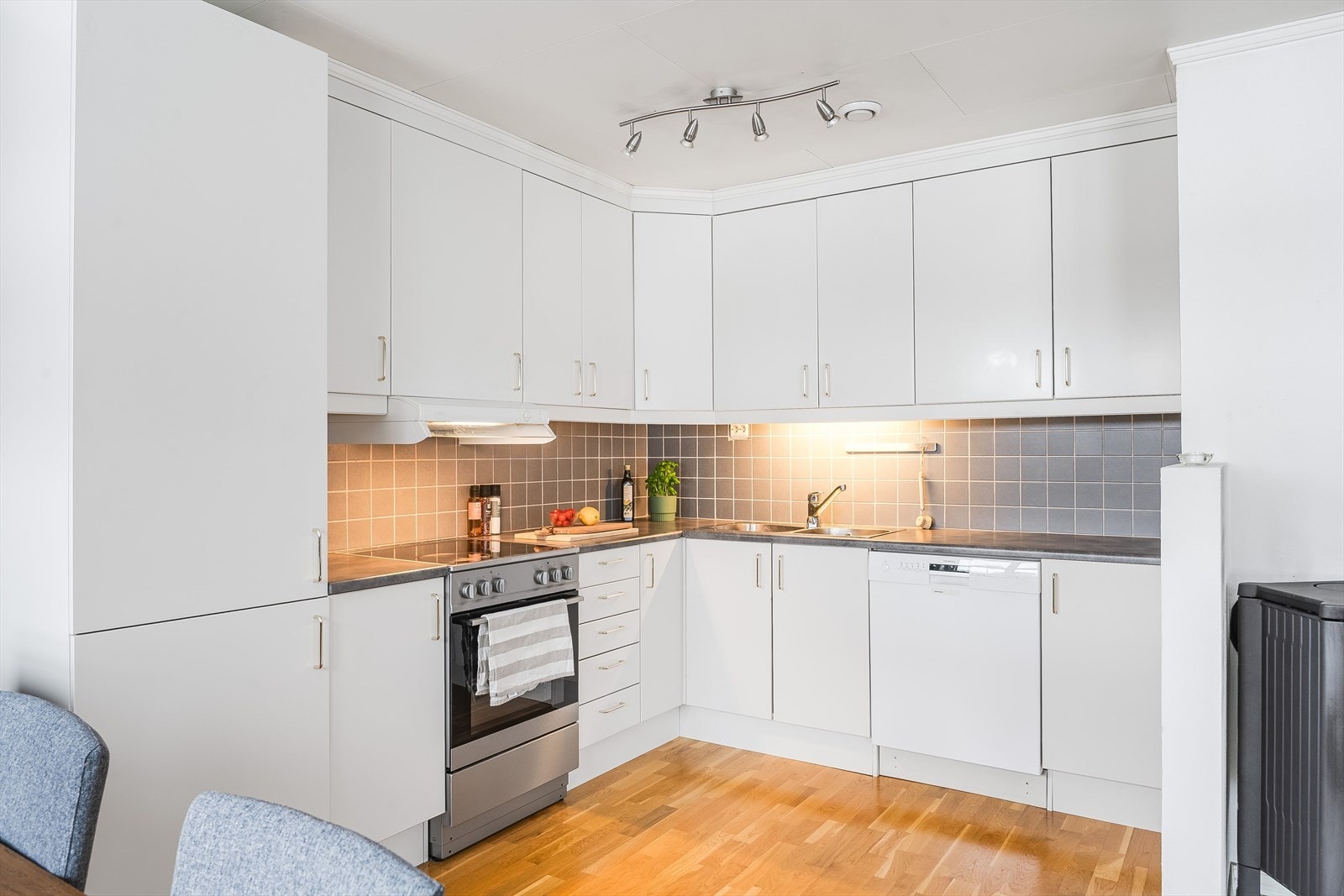 Lys og moderne kjøkkeninnredning fra 2007 med god skap- og benkeplass. Innredningen har hvite glatte fronter og laminert benkeplate med nedfelt oppvaskkum. Galleribilde