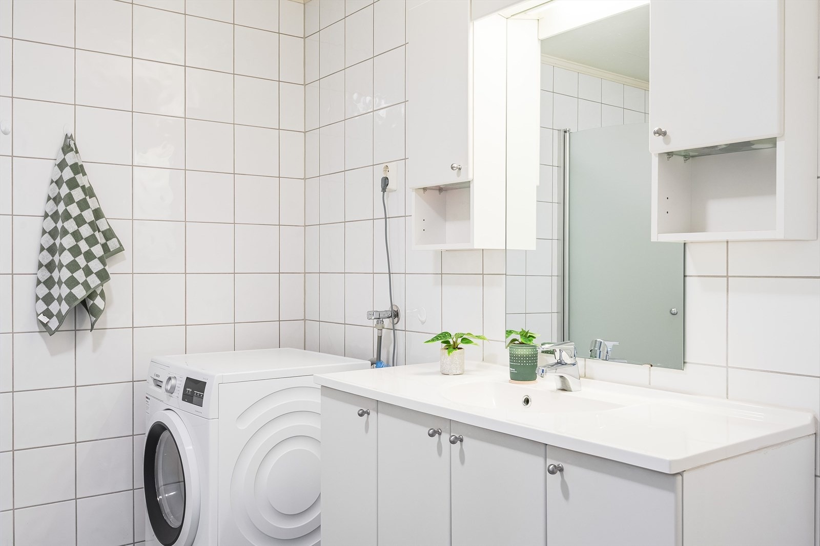 Leiligheten har et lyst og tidløst flislagt baderom fra byggeåret 2007. I hjørnet er det plass og opplegg for vaskemaskin og tørketrommel over om ønskelig. Galleribilde