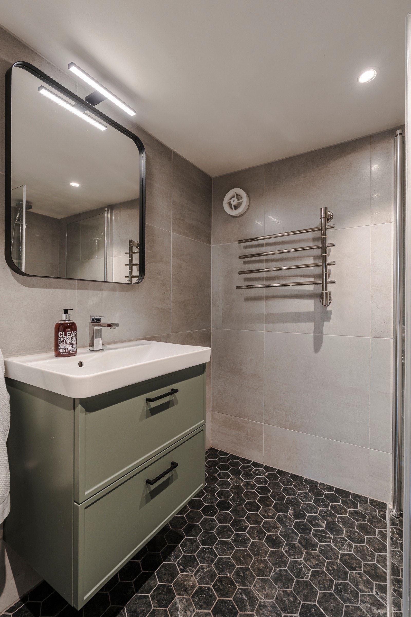 Badet i underetasjen ble pusset opp i 2019 - det er satt opp en vegghengt hylle fra Vedum i samme grønnfarge som servantskuffene. Galleribilde