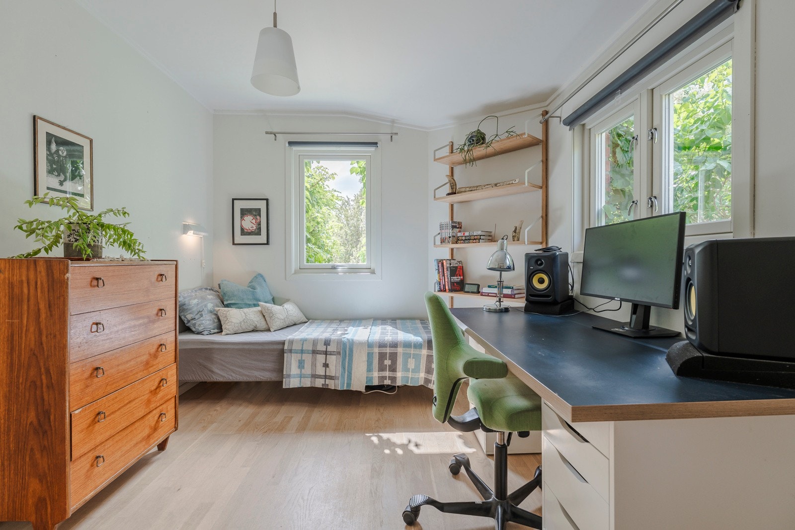 Soverom med idyllisk utsyn og lysinnslipp fra to sider mot syriner og andre vekster i frodig bakhage med nydelig ettermiddagslys. Galleribilde