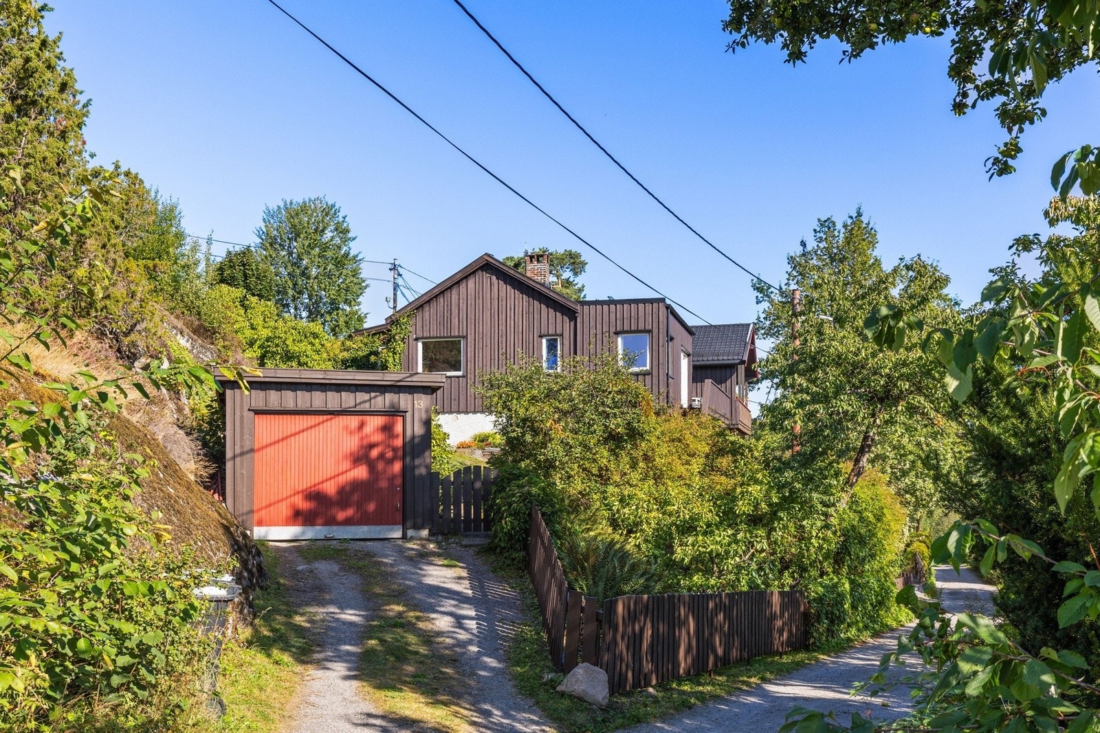Separat garasje ved innkjørsel til eiendommen, samt biloppstillingsplass foran garasjen til 1-2 biler. Galleribilde