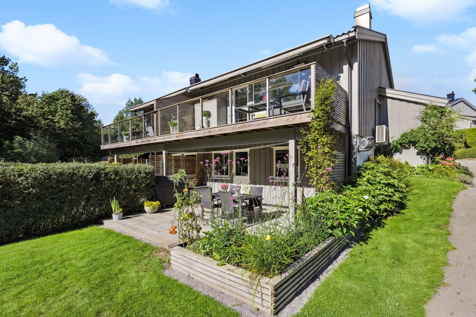 Hyggelig hage som er pent opparbeidet med plen og flott beplantning. Galleribilde