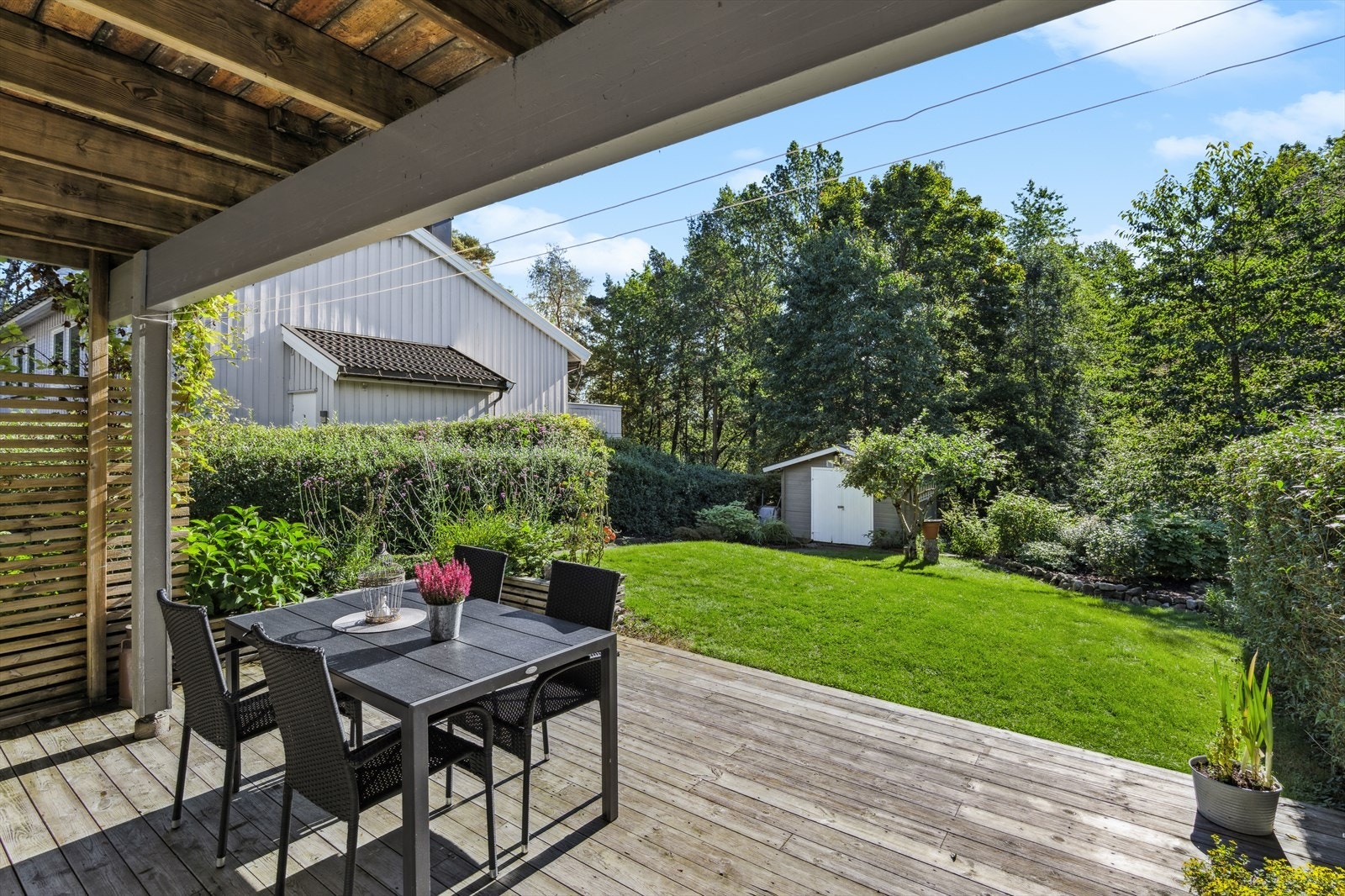 Lun og hyggelig uteplass i tilknytning til hagen. Plattingen er overbygget så her sitter man godt i le for vær og vind. Galleribilde