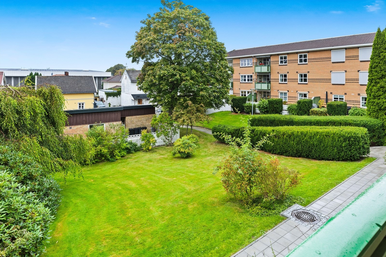 Pent opparbeidet fellesområder med gressplen og diverse beplantning. Galleribilde