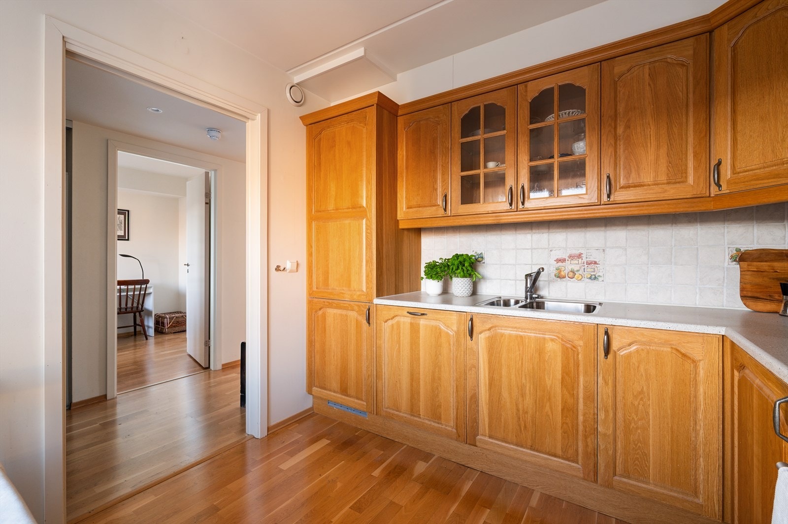 Fliser og belysning under overskap. Integrert induksjonstopp, stekeovn, kjøleskap og oppvaskmaskin, samt ventilator over kokeplass. Galleribilde