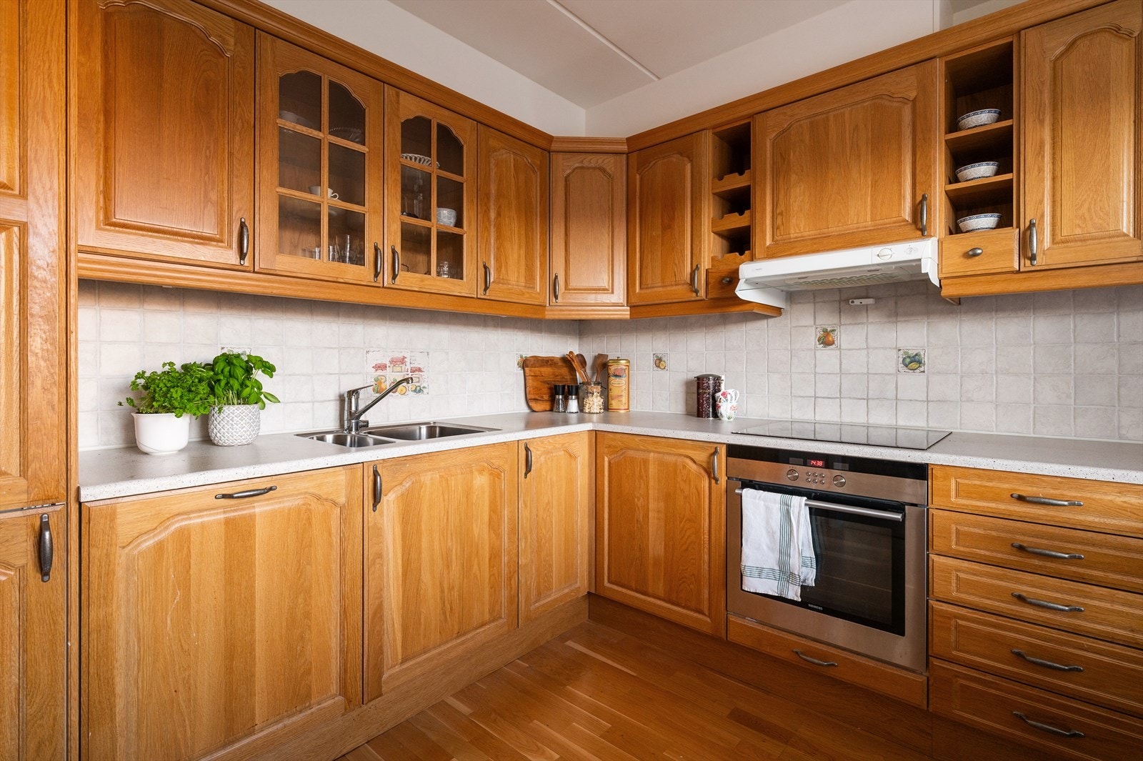 Kjøkkeninnredning med profilerte fronter og laminat benkeplate med nedfelt vask- og skyllekum. Det er god skap- og benkeplass på dette kjøkkenet. Galleribilde