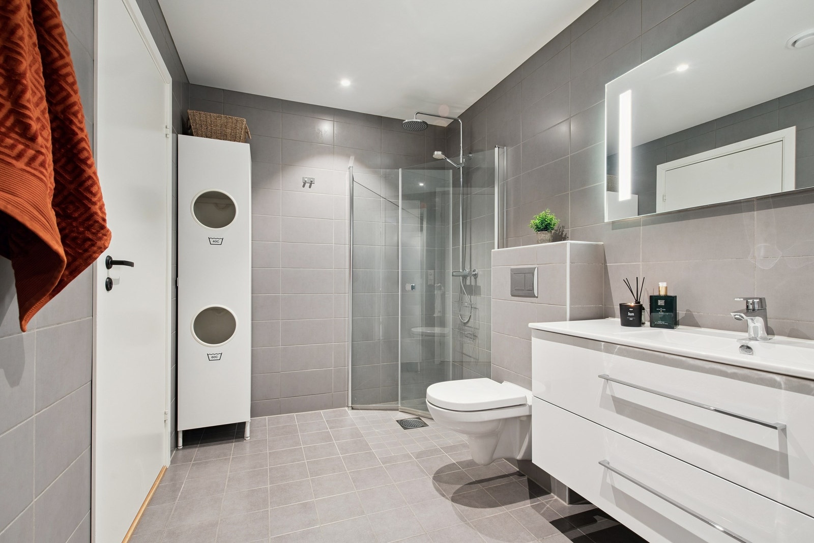 Helfliset bad i første etasje med gulvvarme, vegghengt toalett og innfellbare dusjdører. Galleribilde