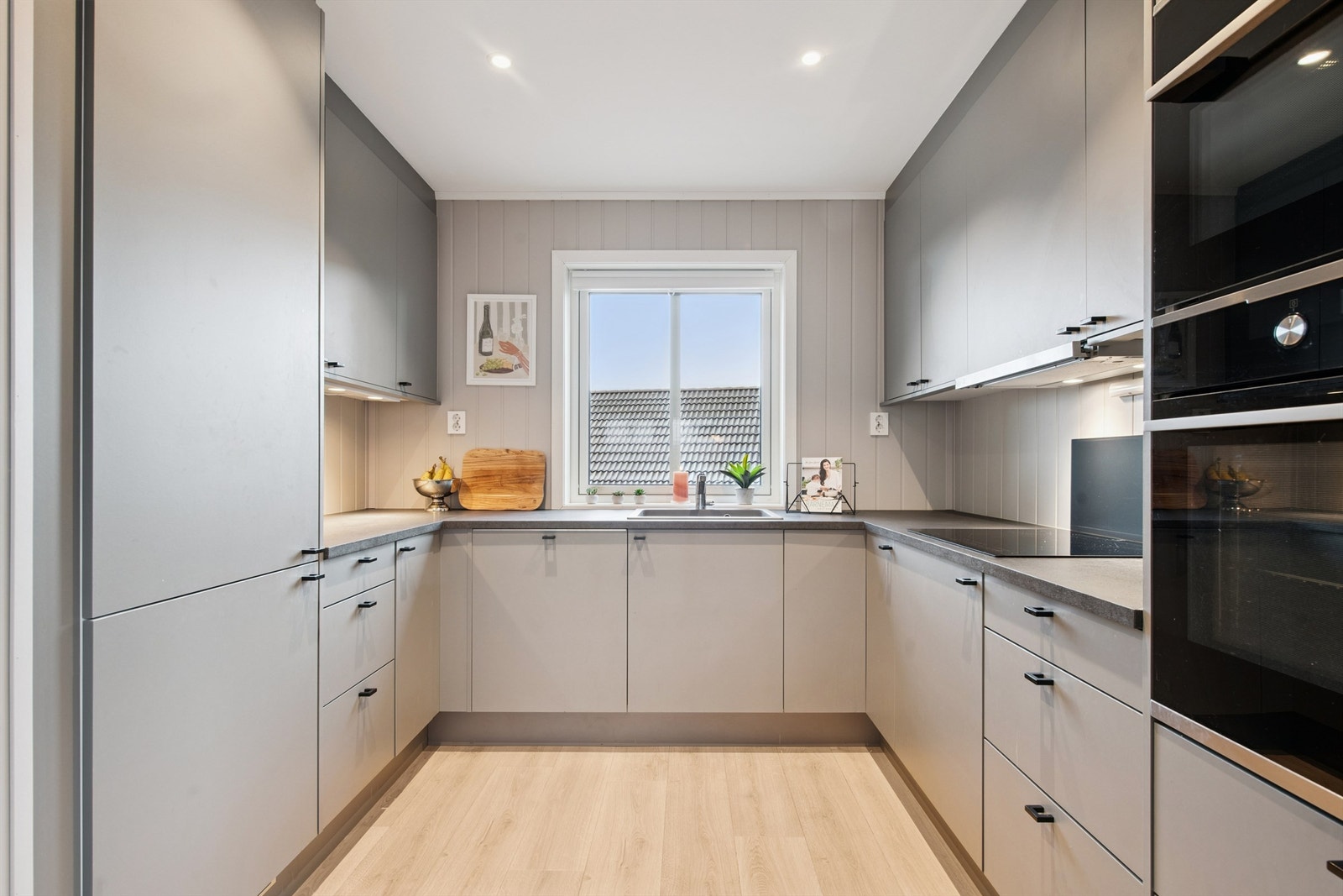 Moderne kjøkkeninnredning med slette fronter og godt med skap- og benkeplass. Galleribilde