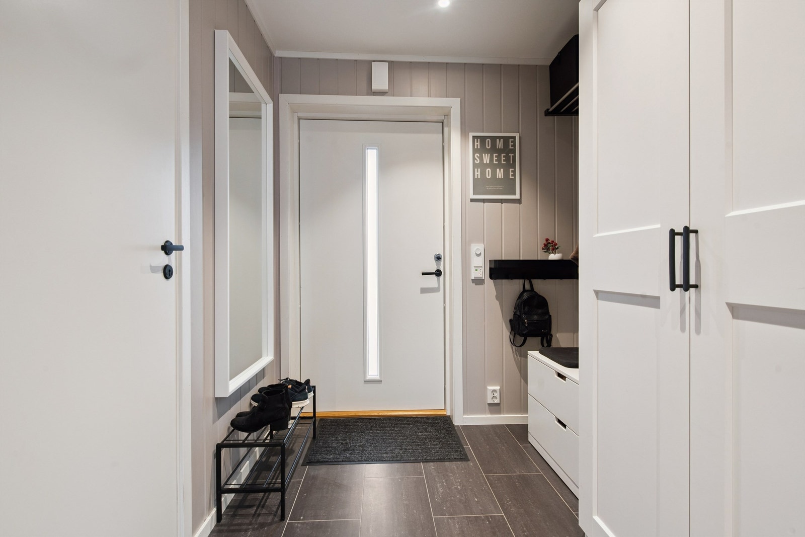 Velkommen inn i en praktisk entré med flislagt gulv og behagelig gulvvarme. Galleribilde