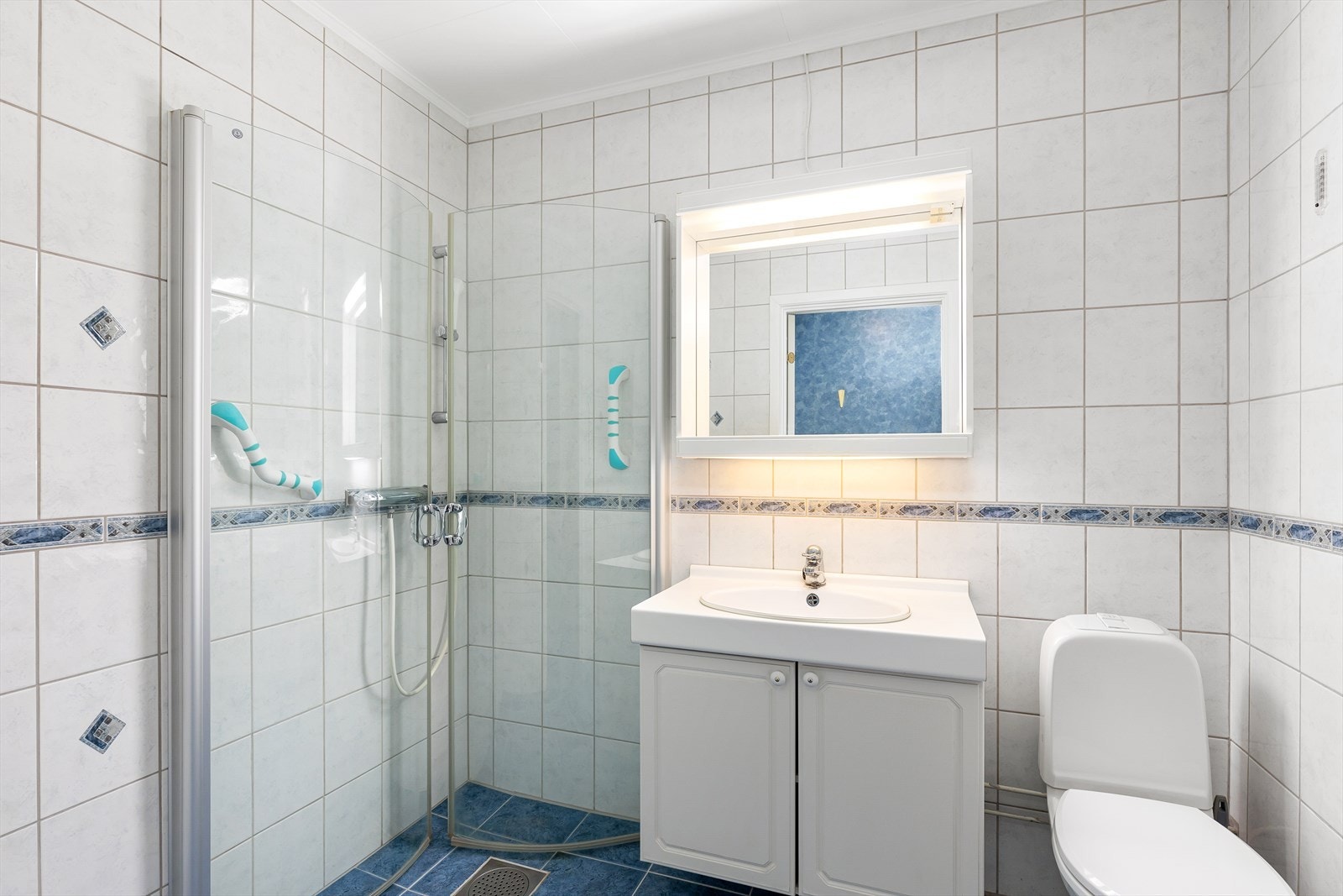 Bad med fliser på gulv og vegger. Det er malte plater i tak Galleribilde