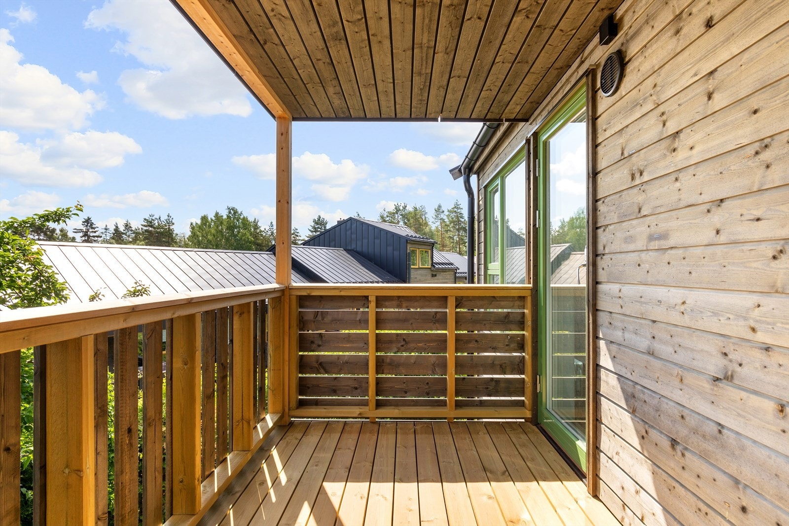 Den nye balkongen med tak. Balkongdør med stor glassflate bringer mye lys til stuen Galleribilde