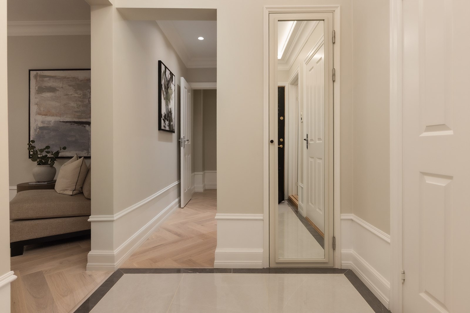 Videre i gangen er det lagt lekker fiskebensparkett i eik med varme i gulv. Her er det god plass til oppbevaring med integrerte skap. Galleribilde