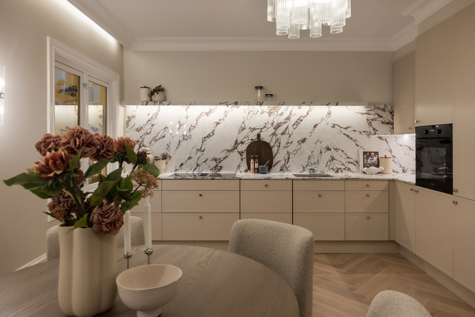 Integrerte hvitevarer fra Miele, inkludert induksjonstopp med kullfilterventilator, stekeovn, oppvaskmaskin og kjøl fryseskap. Galleribilde