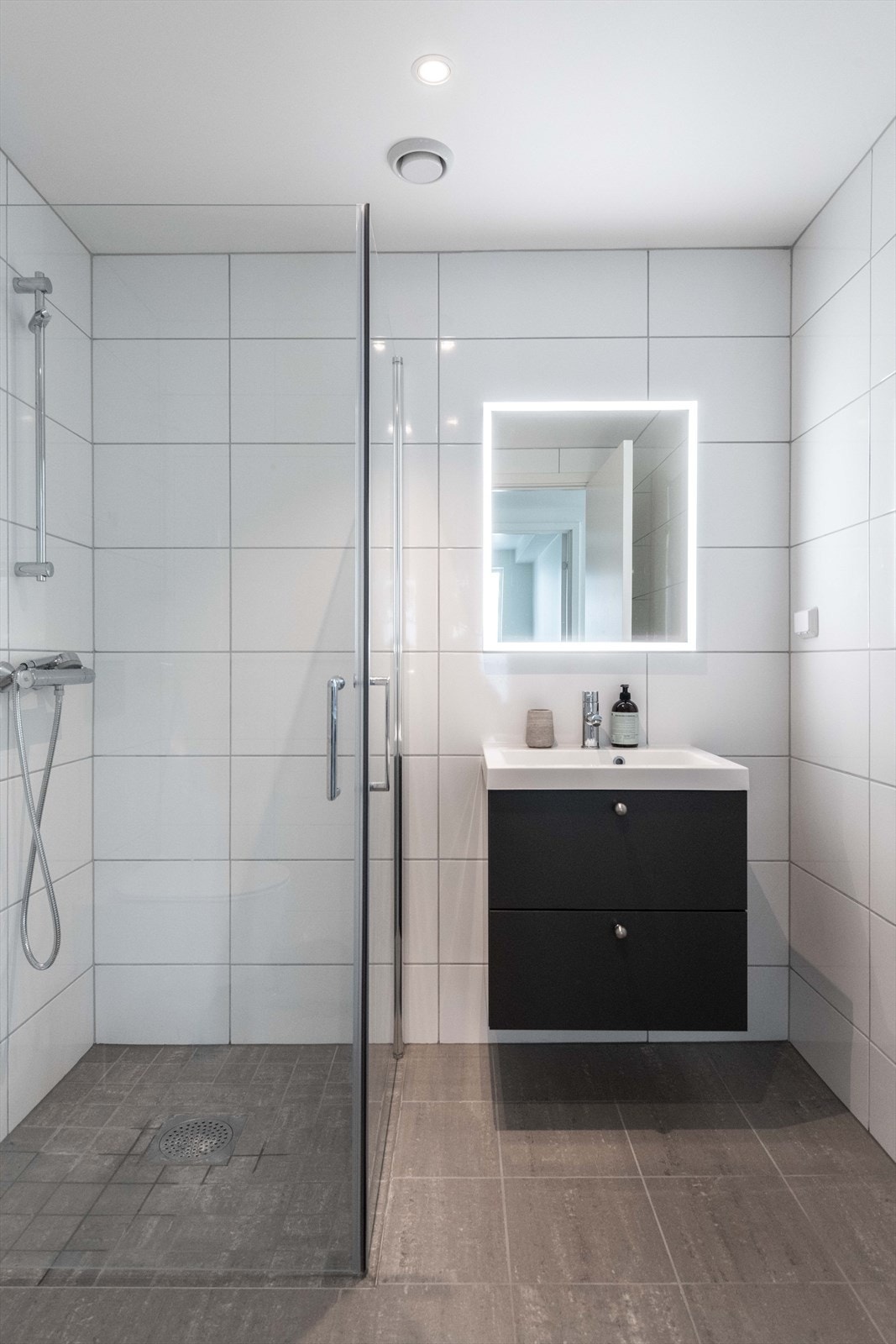 Innredet med nedfelt servant, veggfestet toalett og dusjnisje. Galleribilde