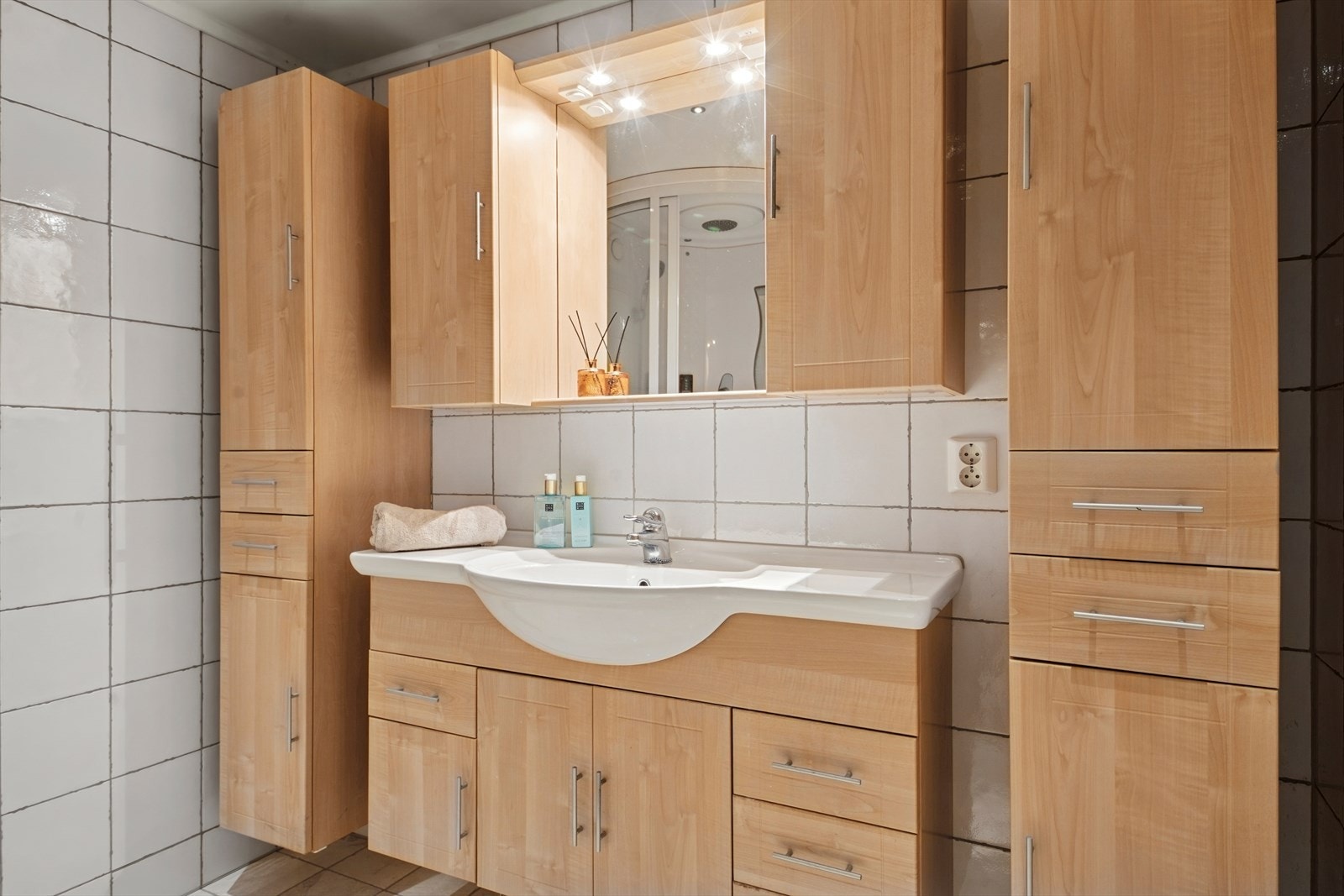 Badet er fra ca. 2007 og er innredet med en baderomsinnredning med heldekkende servant, speil, høyskap, veggmontert toalett og dusjkabinett. Galleribilde