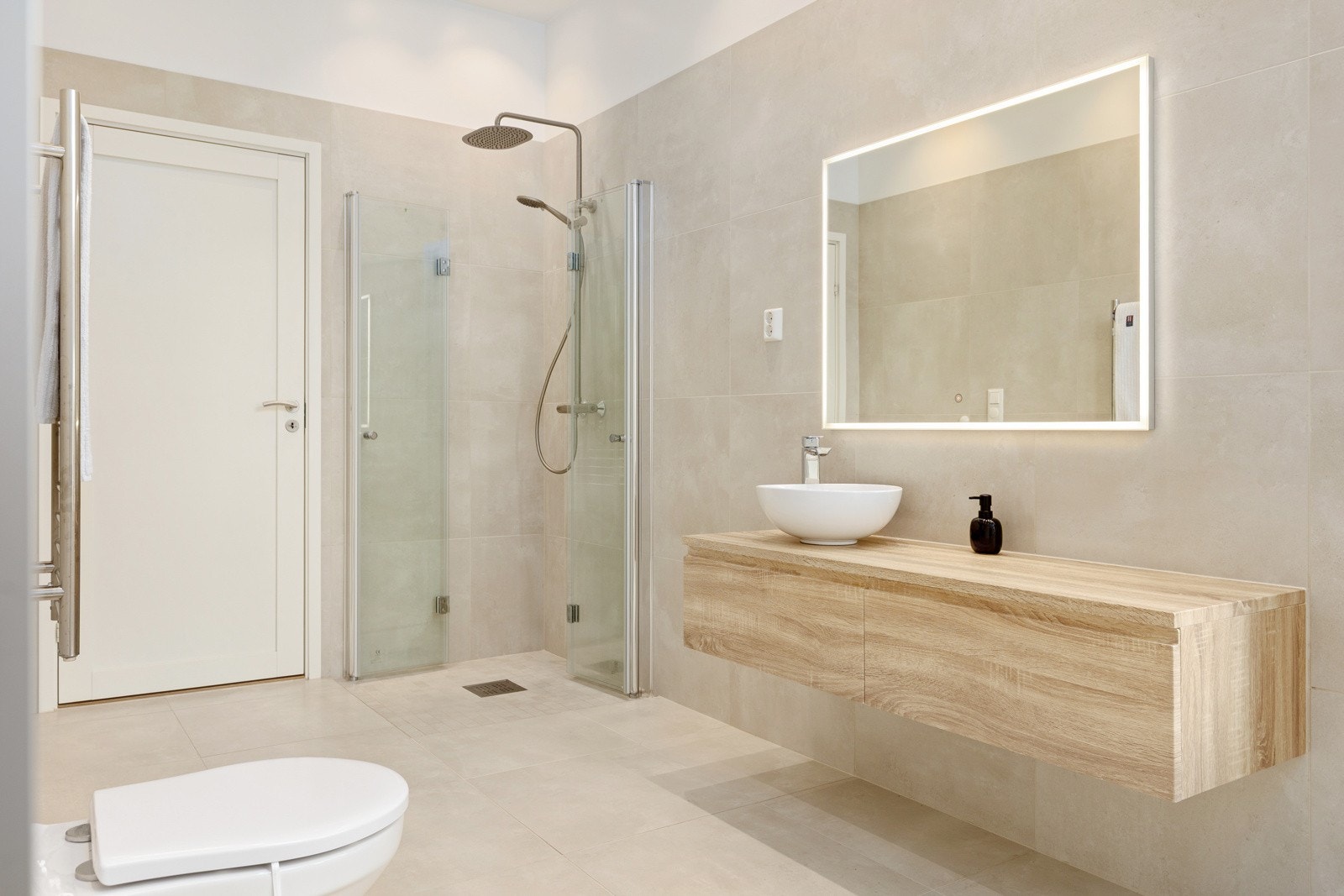 Rommet er utstyrt med nedfelt servant, vegghengt toalett, håndklevarmer og dusjhjørne Galleribilde