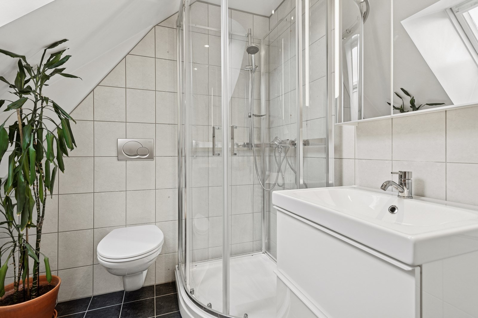 Baderom med flislagt gulv og vegger med slett himling. Galleribilde