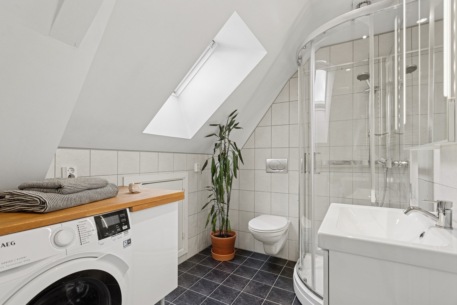 Baderom er innredet med dusjkabinett, vegghengt toalett og servant. Kombinert vask tørk medfølger handelen. Galleribilde