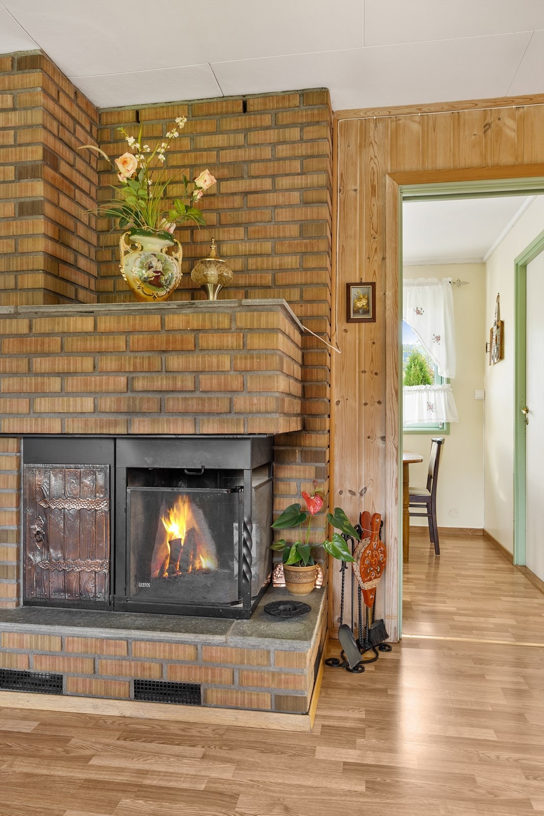 Midt i stuen er det plassert en peisovn på ildfast plate. Denne avgir godt med varme og bidrar med hygge på vinterhalvåret. Galleribilde