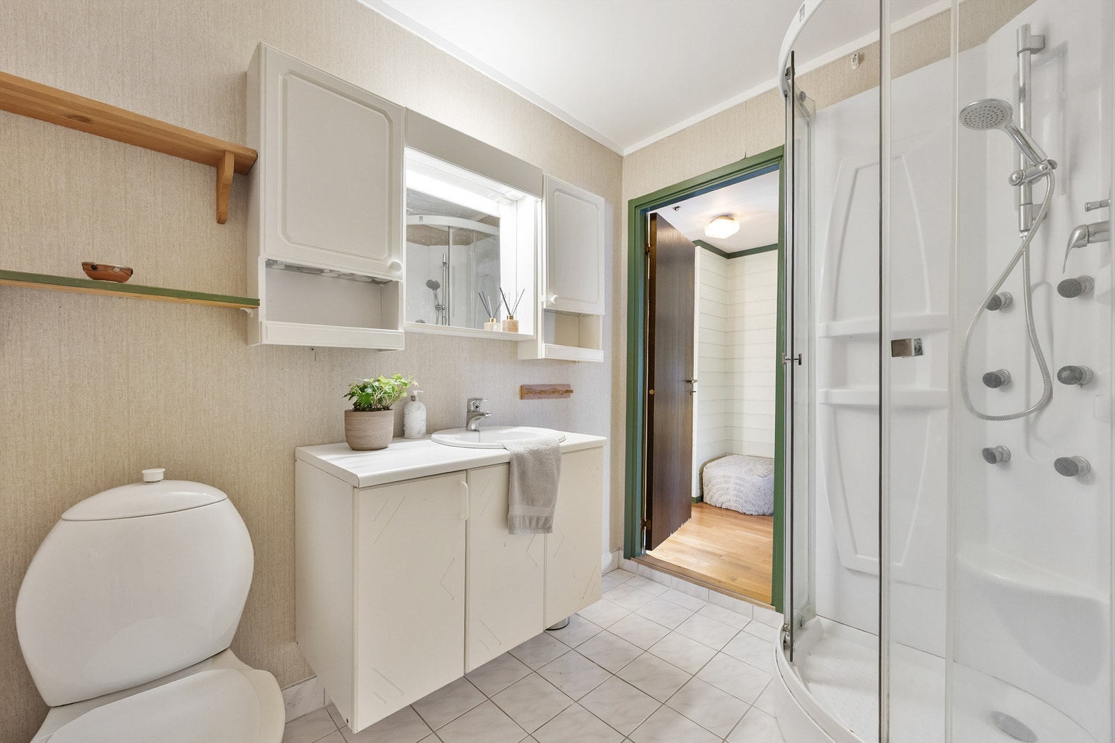 Baderomsinnredning med speilskap og servant med underskap. Dusjing i dusjkabinett. Galleribilde