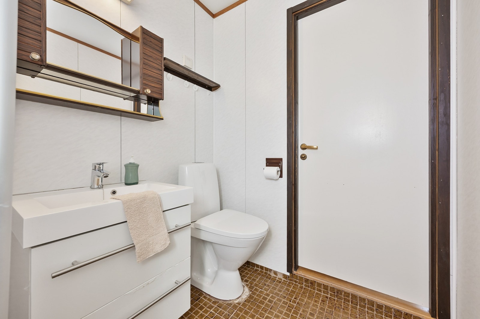 Badet er innredet med servant og underskap med ett-greps armatur, samt overskap med speil og guvlstående toalett. Galleribilde