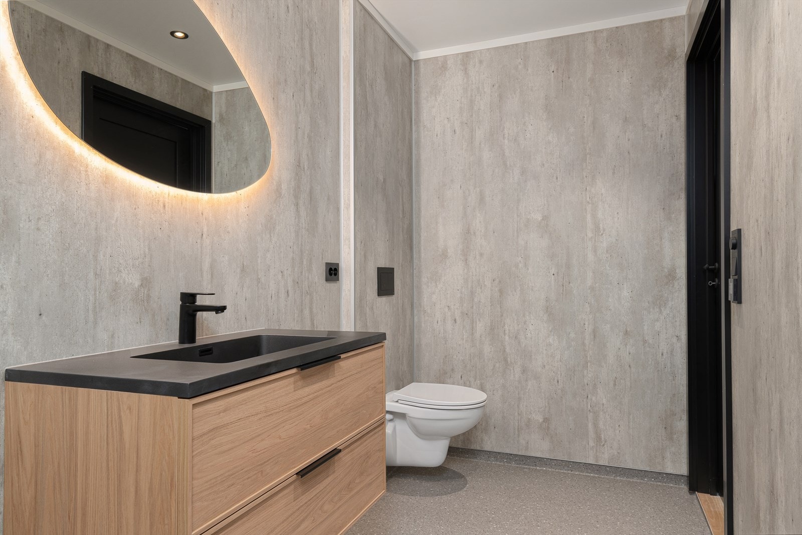 Gjestebadet er videre utstyrt med enkelt servant, vegghengt toalett og åpen dusj med glassvegg. Galleribilde