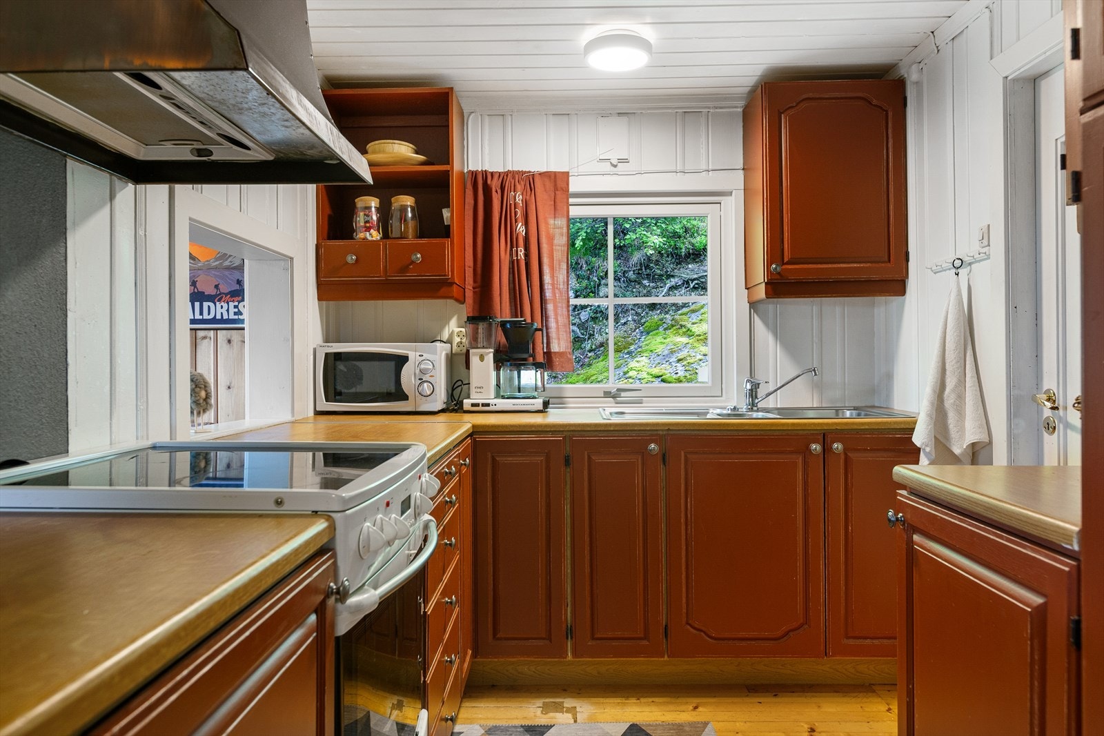 Laminat benkeplate i trefylling og oppvaskkum med kran av stål. Kjøkkenventilator med kullfilter. Galleribilde