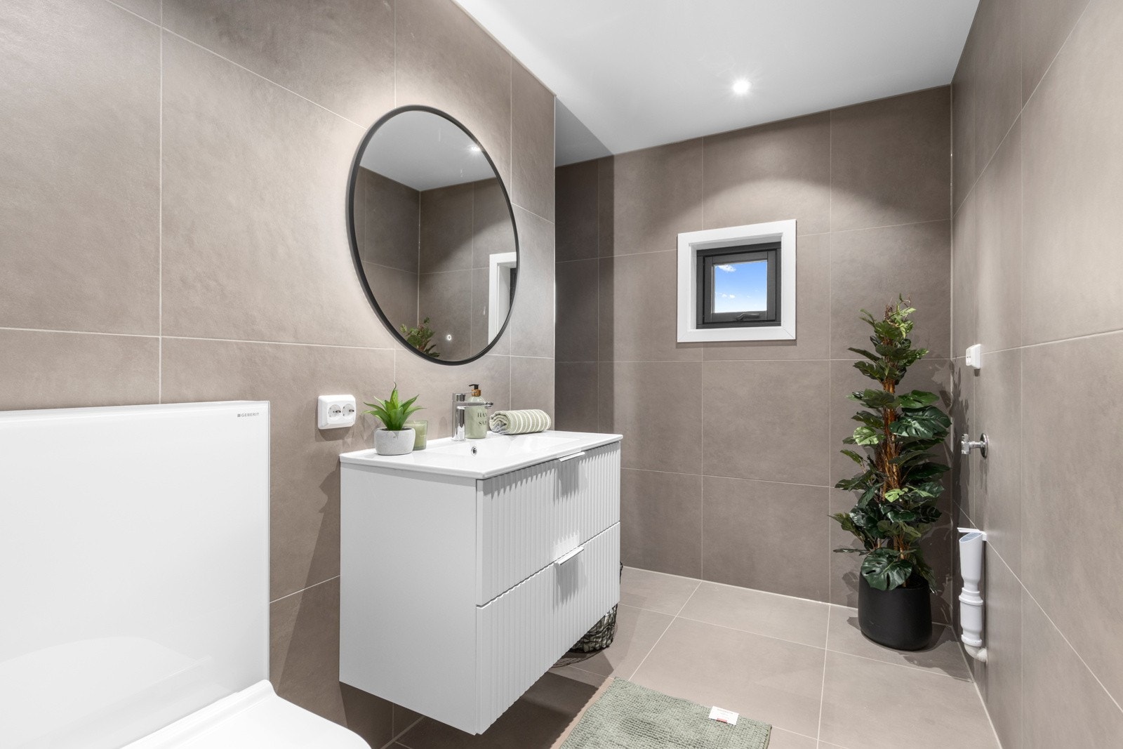 Flislagt bad med opplegg for vaskemaskin. Galleribilde