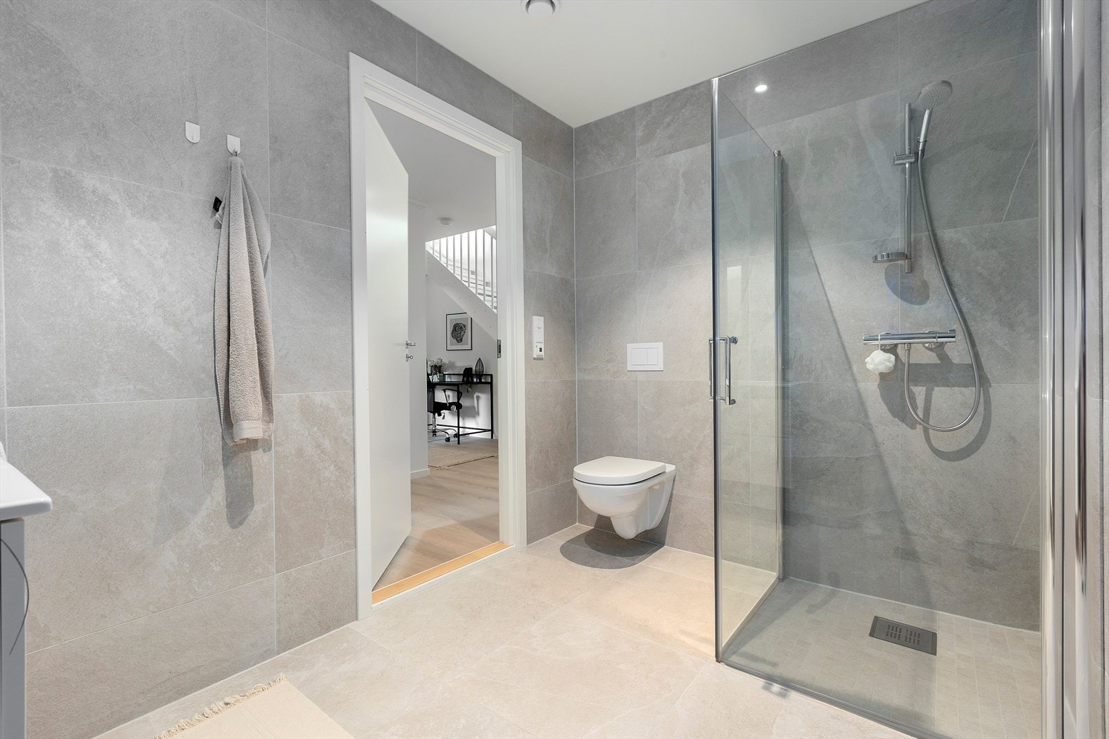 Rommet har elektriske varmekabler og er utstyrt med innredning med nedfelt servant, vegghengt toalett og dusjhjørne med dusjvegger. Galleribilde