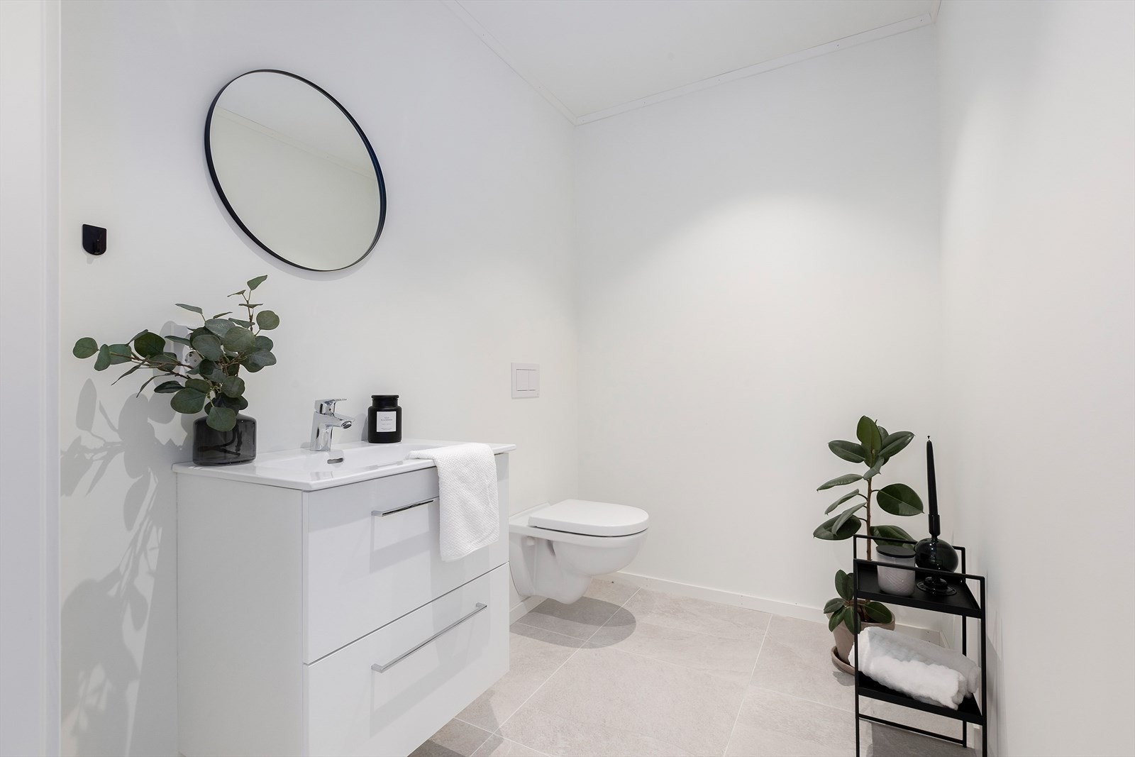 Praktisk separat toalettrom med vegghengt toalett og servant med servantskap. Galleribilde