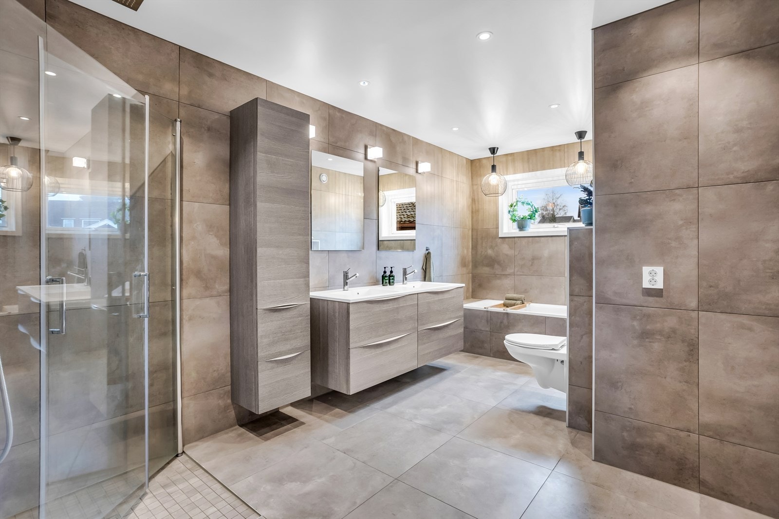 Moderne bad med flislagte overflater, gulvvarme og downlights i himling. Galleribilde