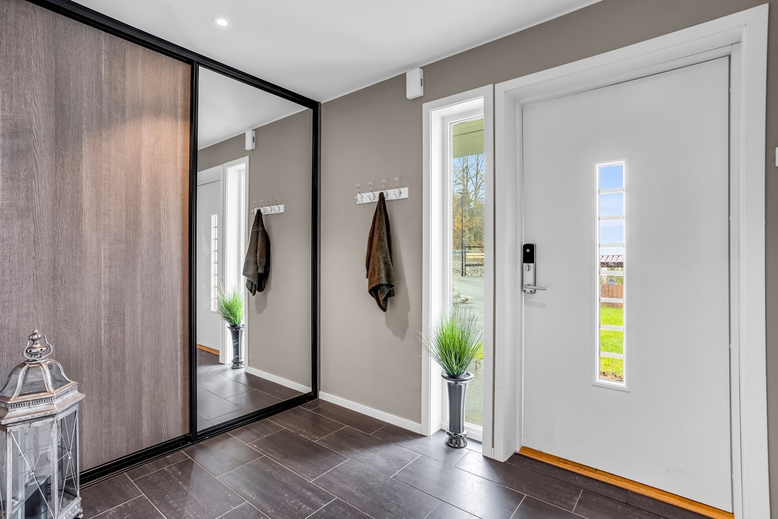 Velkommen inn! Boligen har en innbydende og romslig entré med flislagt gulv og gulvvarme. Galleribilde