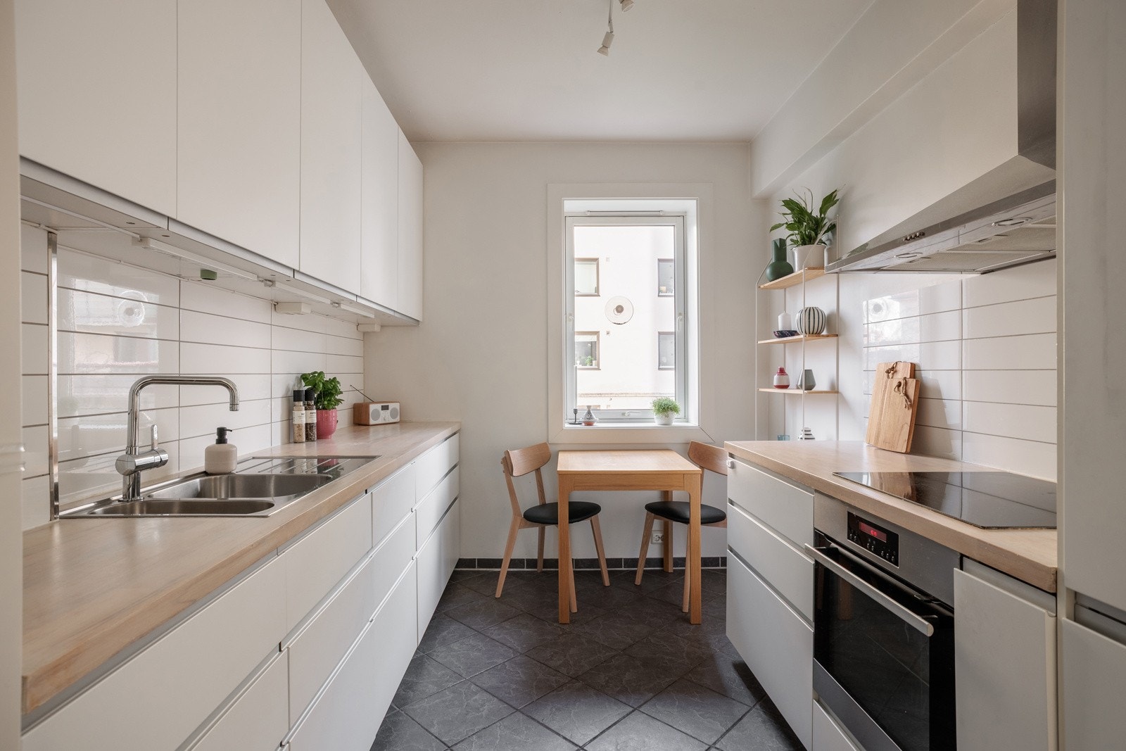 Lyst og tidløst Ikea-kjøkken fra 2014 med god skap- og benkeplass. Innredningen har hvite glatte fronter og benkeplate av tre (slipt i 2022) Galleribilde