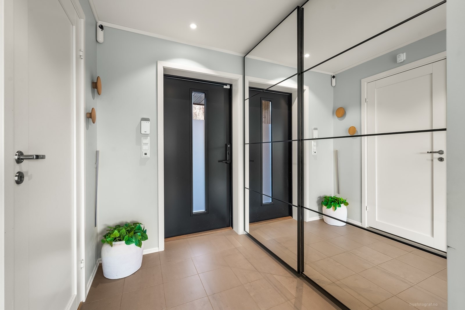 I gangen er det fliser og praktiske skyvedørsgarderobe til oppbevaring. Galleribilde