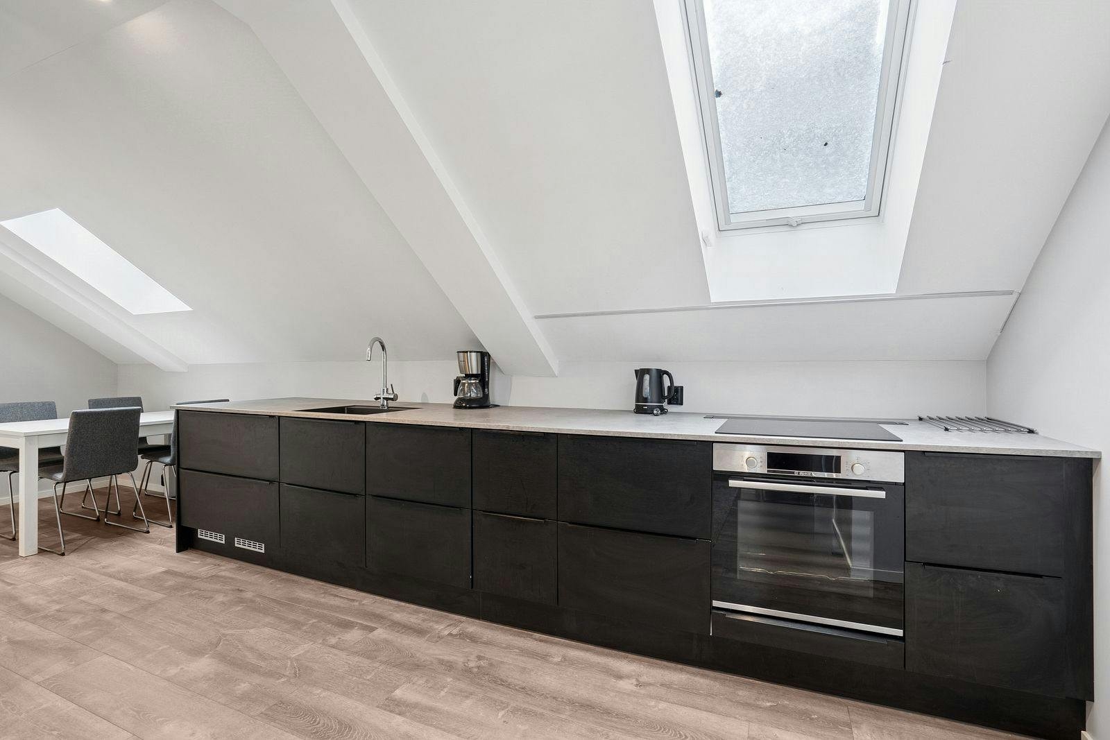 Stort kjøkken med god benkeplass og hvitevarer. Galleribilde