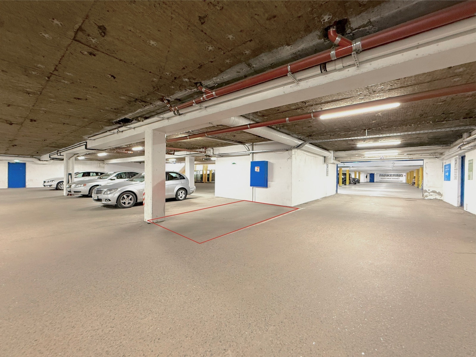 Oppmerket fast parkeringsplass i garasjekjeller, slik at bilen står trygt og tørt året rundt Galleribilde