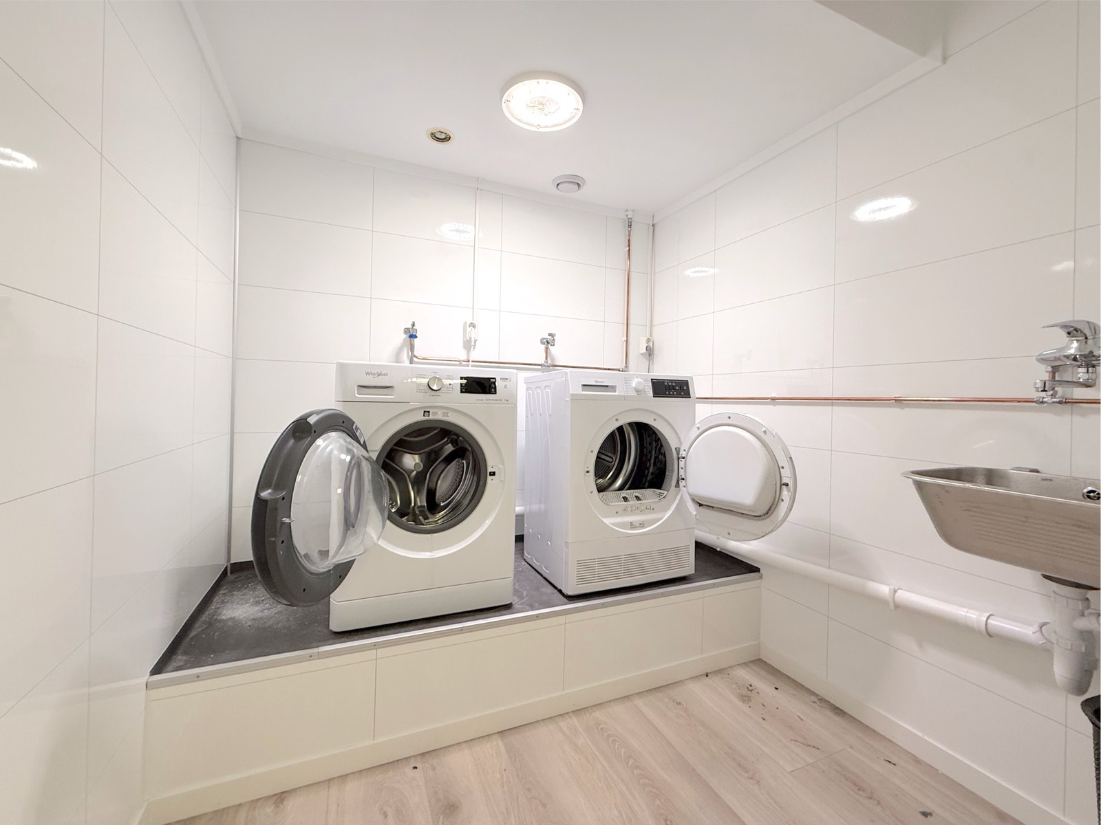 Felles vaskerom i bygget med vaskemaskiner og vaskekum tilgjengelig i umiddelbar nærhet til leiligheten Galleribilde