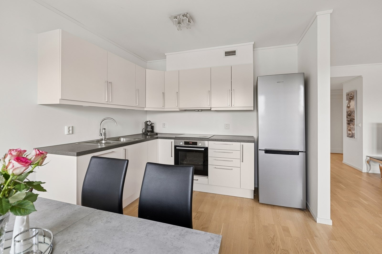 Kjøkkenet er innredet i en praktisk form i rommet, og ligger i åpen løsning til stuen som gjør rommet mer sosialt ved besøk. Galleribilde