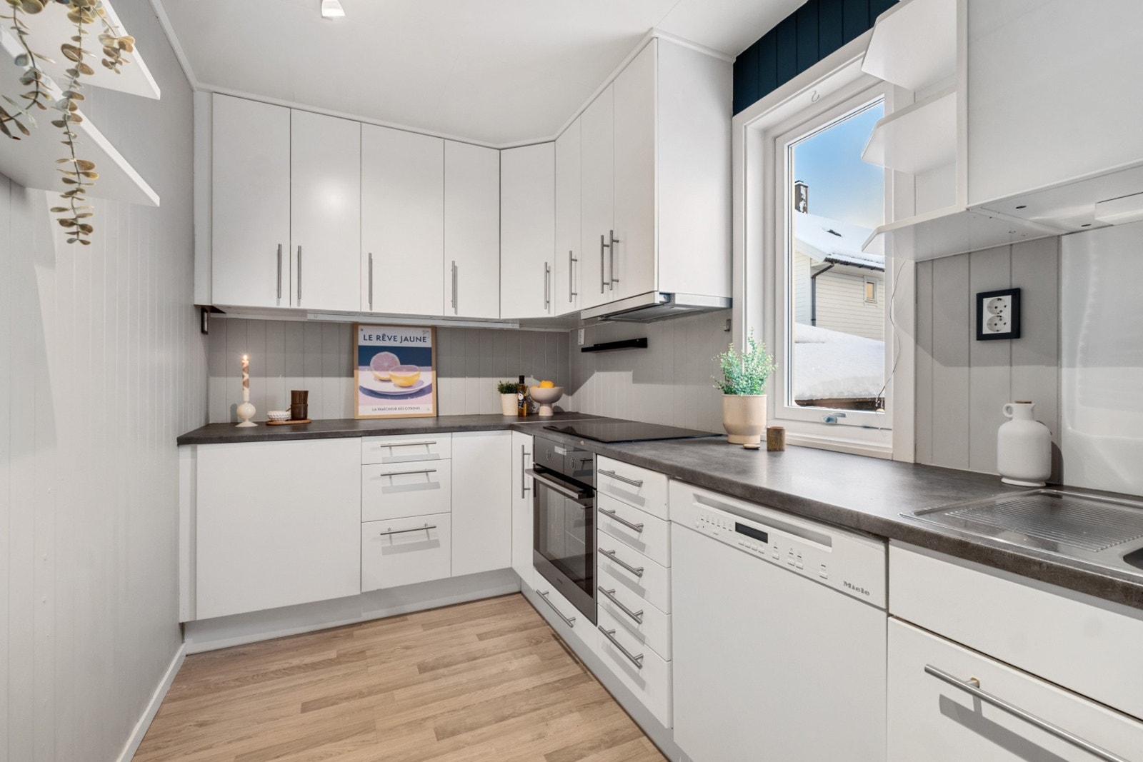 Kjøkkenet har innredning med slette fronter og benkeplate av laminat. Galleribilde