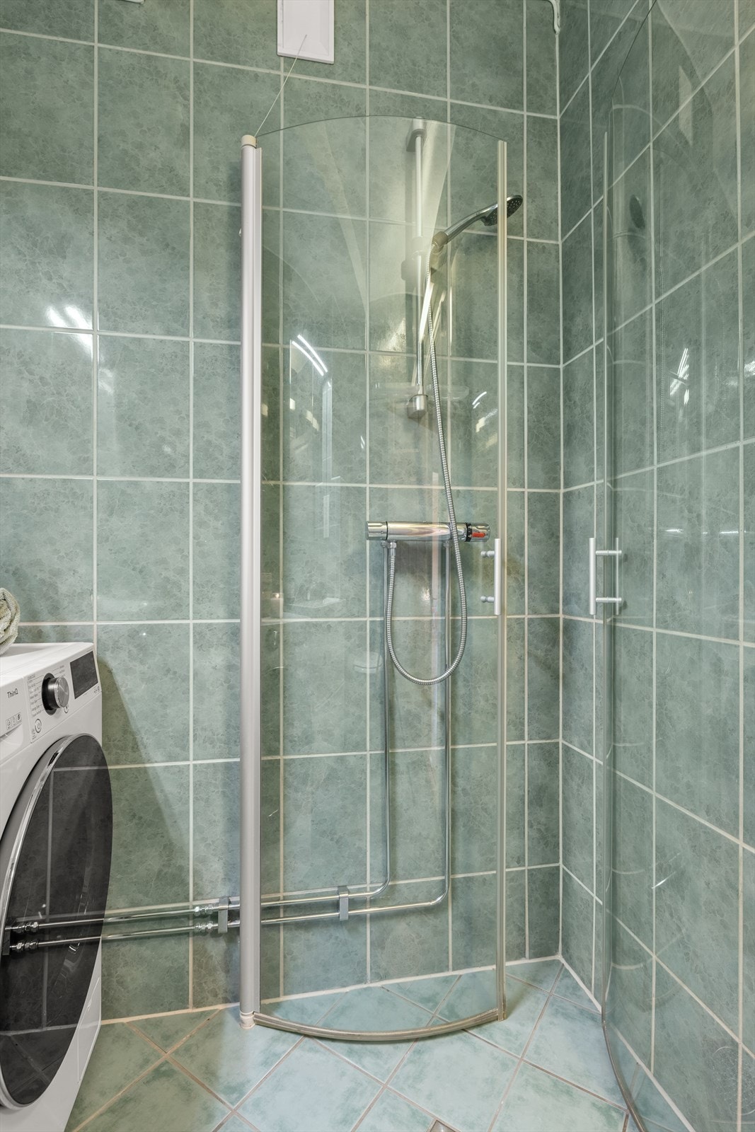 Badet har også praktisk dusjhjørne med innfellbare dusjdører. Galleribilde