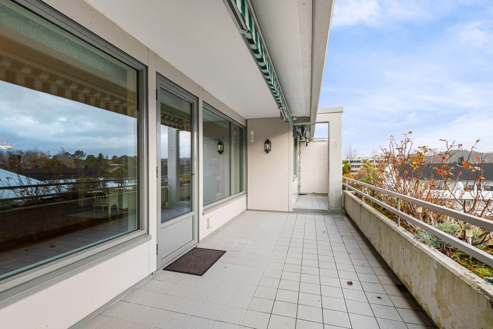 Flislagt dels overbygd terrasse mot syd med markiser Galleribilde