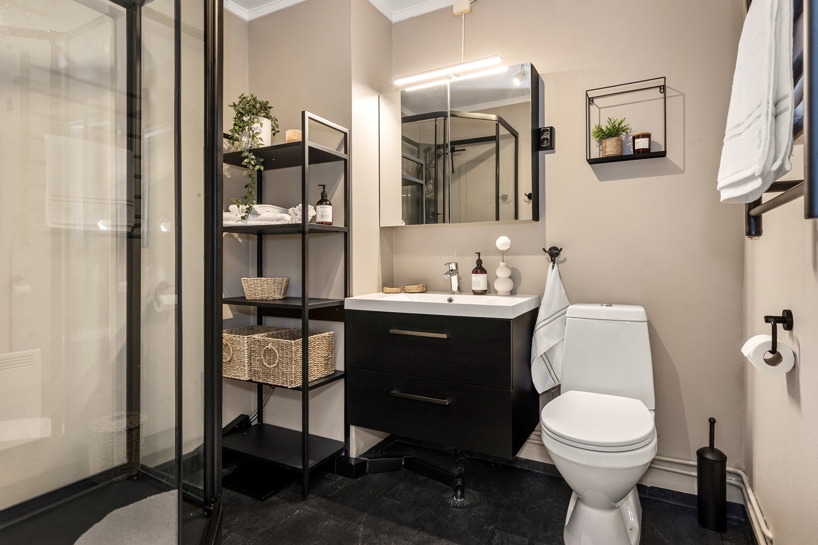 Badet har dusjkabinett og panelovn som varmekilde Galleribilde