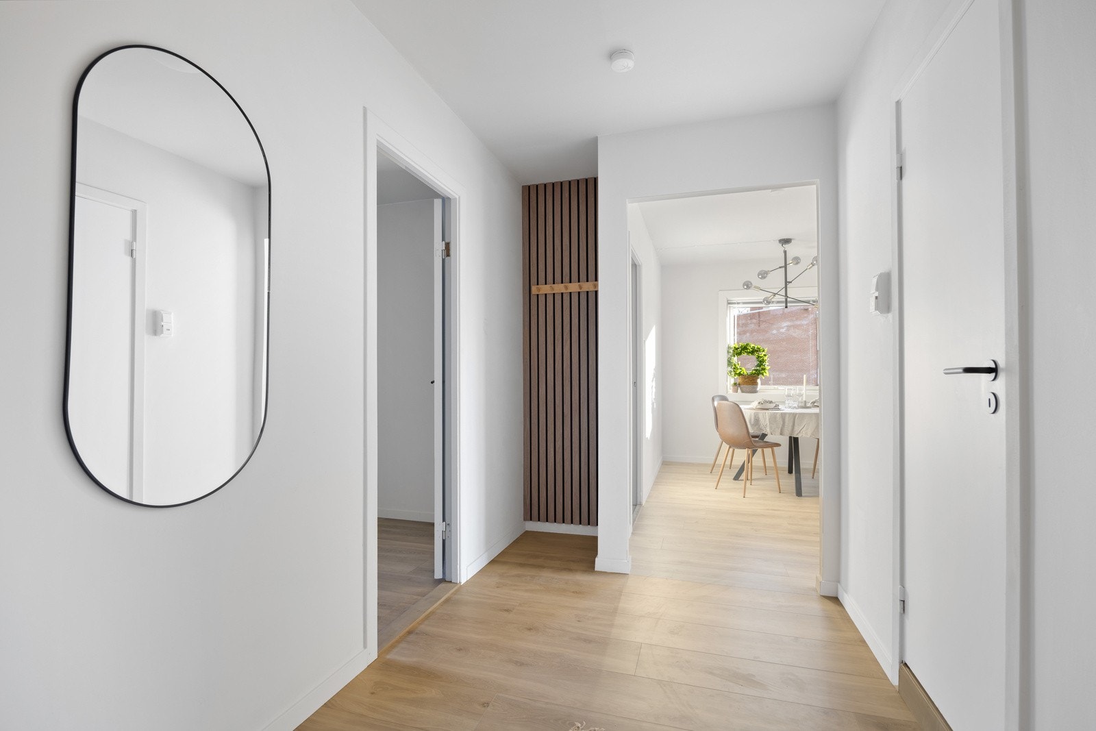 Boligen har romslig entré med eikedetaljer og praktisk oppbevaring, lys og delikat stue med plass til både sofagruppe og spisebord, samt et lyst og moderne kjøkken med glatte fronter og laminatbenkeplate. Galleribilde