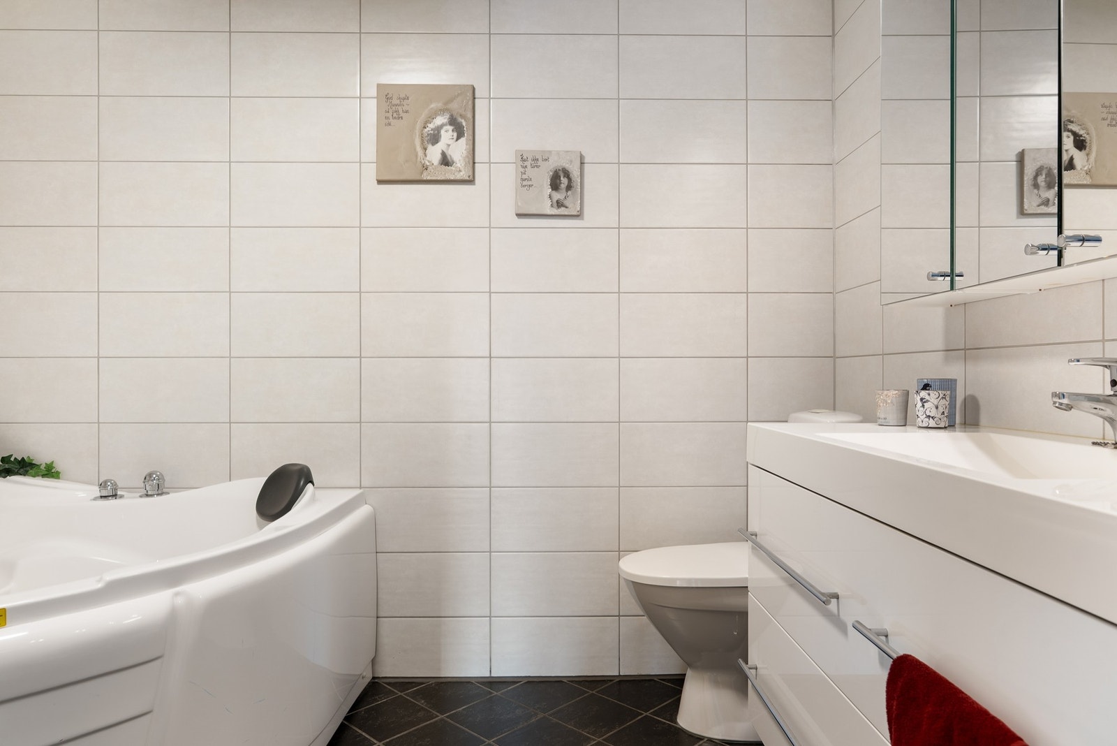 Lyst og romslig bad med servantinnredning, badekar og toalett. Galleribilde